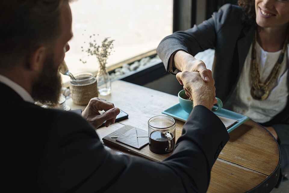 Two people shaking hands to agree on a home sale