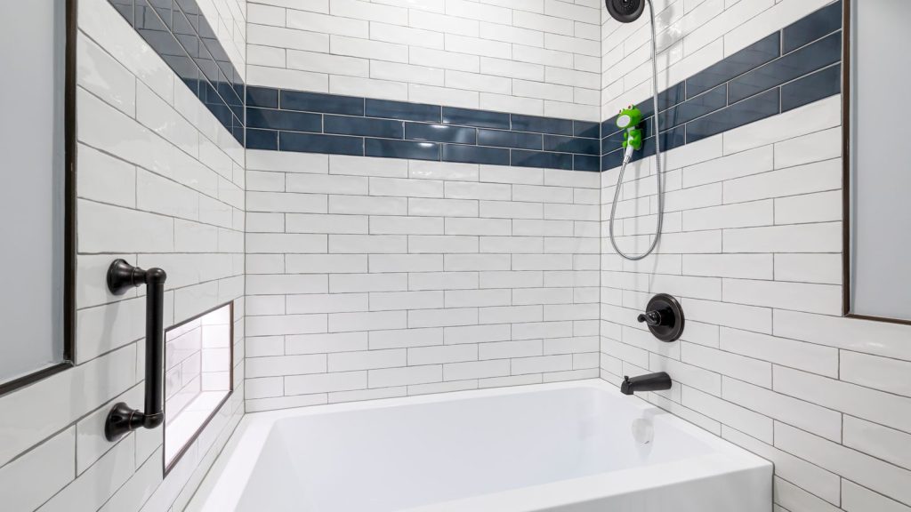 Compact modern bathroom with white fixtures and blue tile accents
