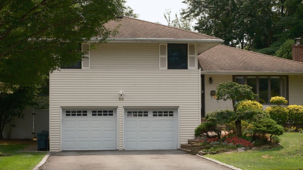 Suburban house with a double garage door and landscaped front yard