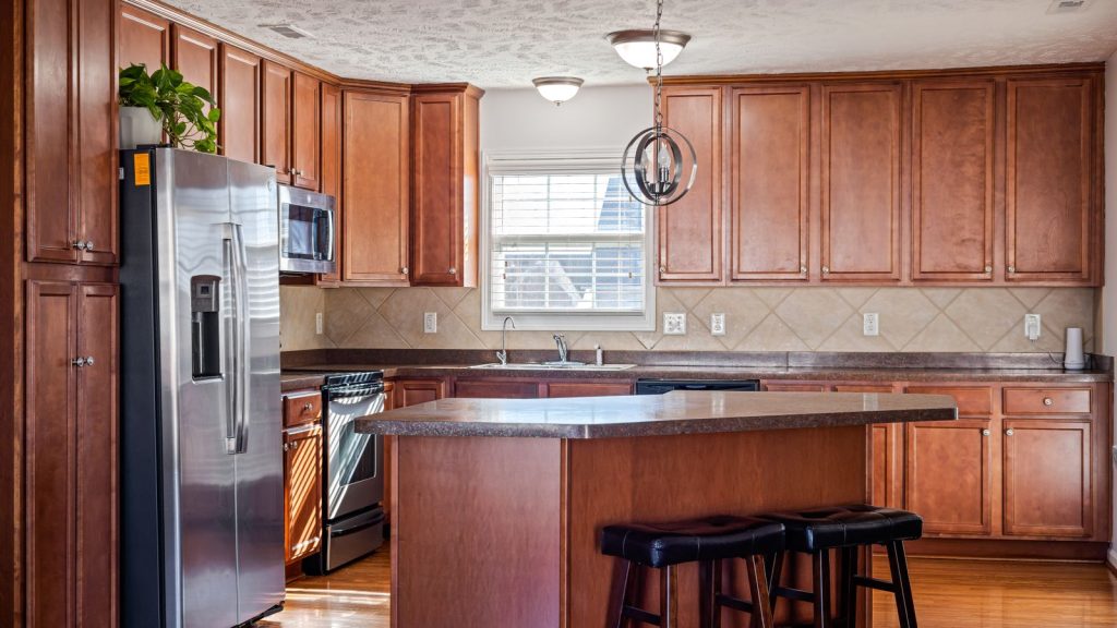 Kitchen with semi custom wood cabinets, island and stainless appliances