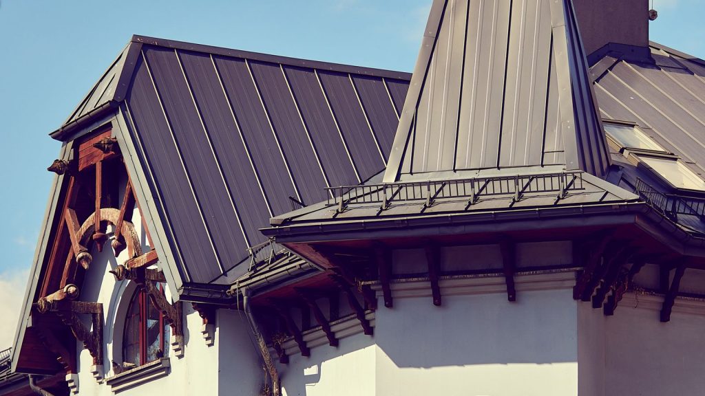 Standing seam metal roof panels on a steep gabled house