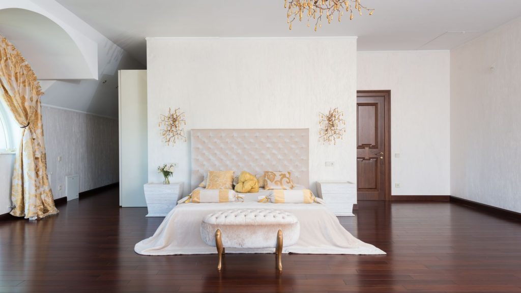 Spacious light filled bedroom with queen bed and bench