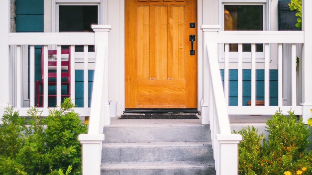 Inviting front porch of a suburban house with a classic entry door