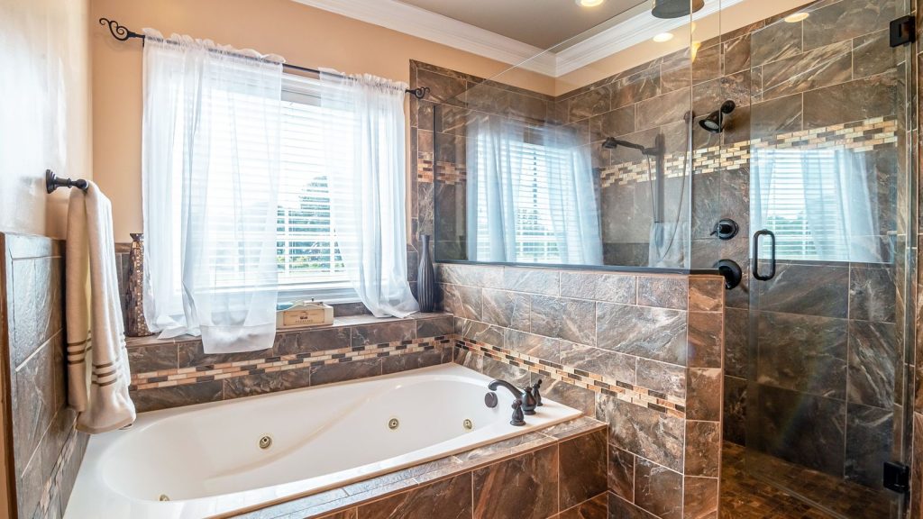 Upscale bathroom with soaking tub, stone tile and a glass walk in shower