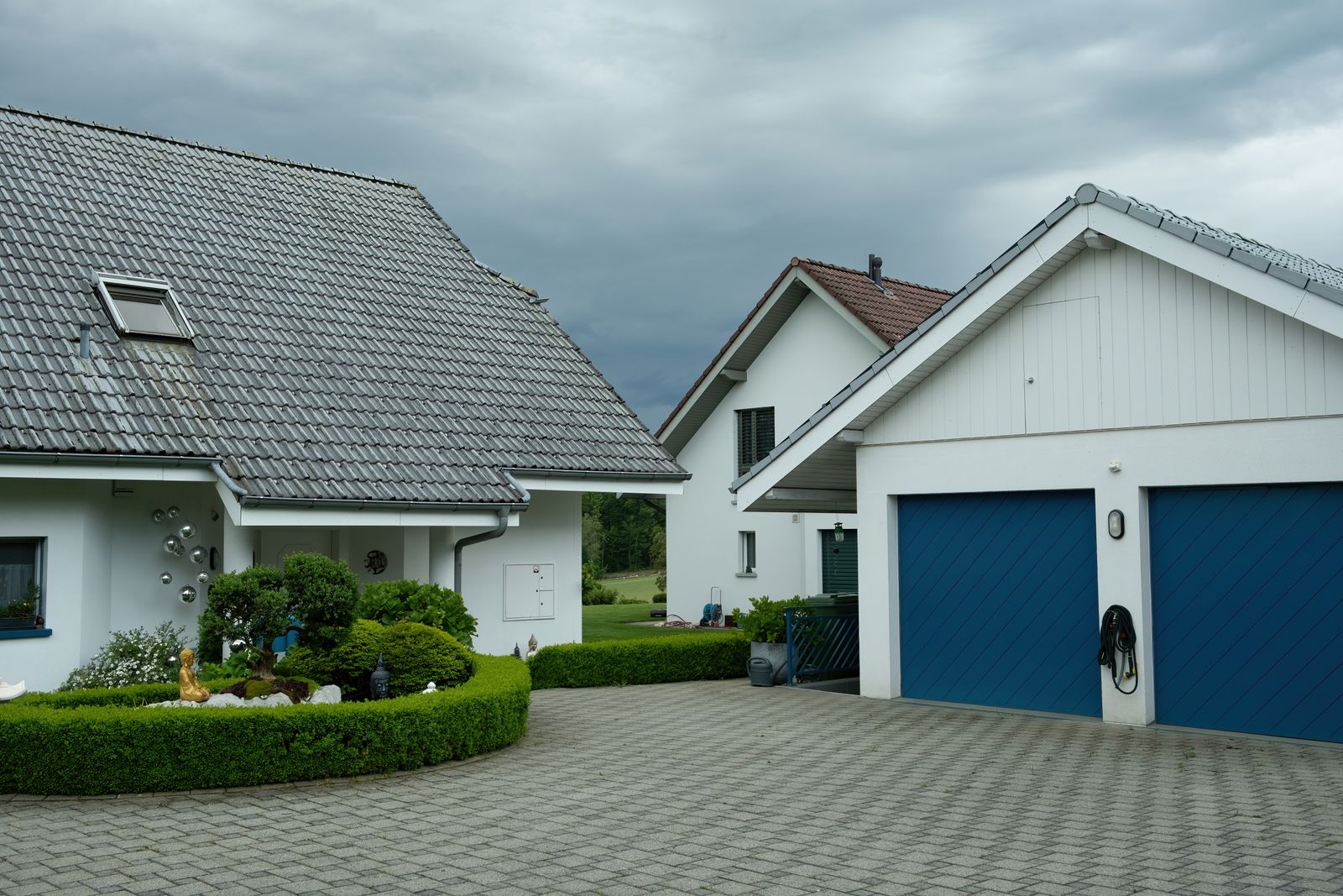 Suburban houses with blue garage doors surrounded by greenery