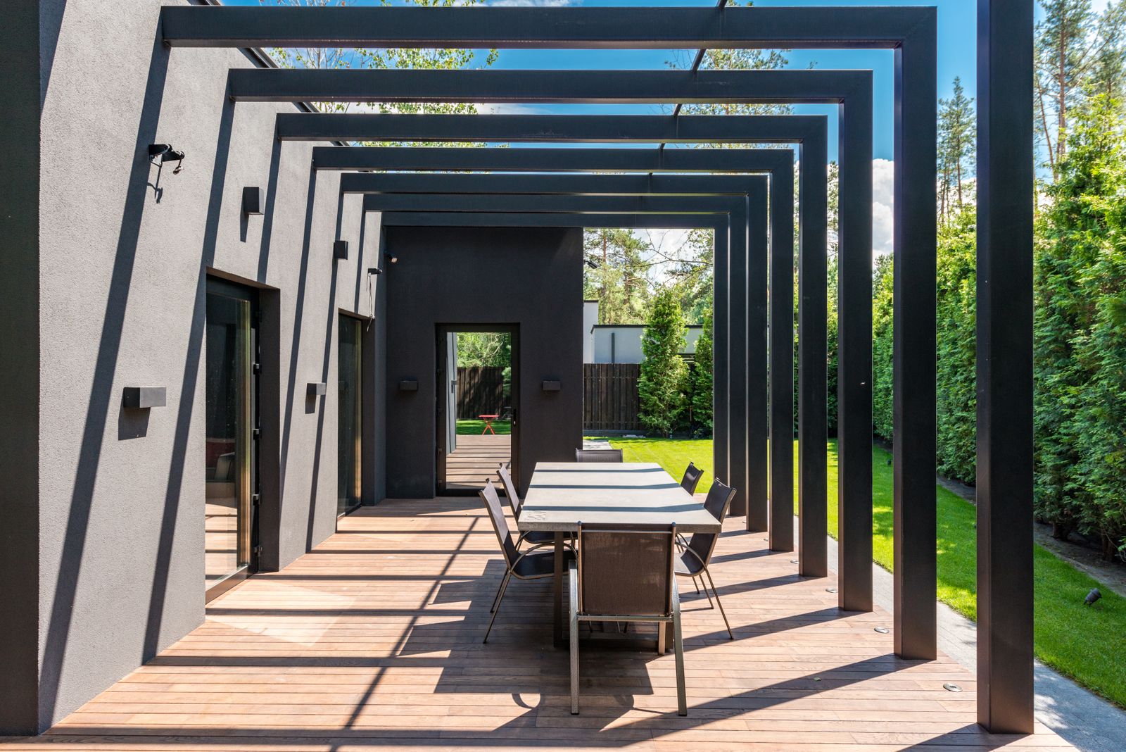 Patio with pergola and outdoor dining set on a wooden deck